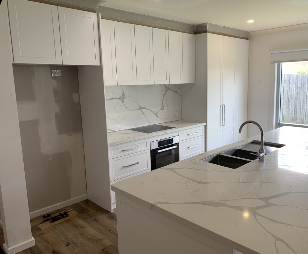 kitchen renovation in progress, all white cabinetry and stone benchtop